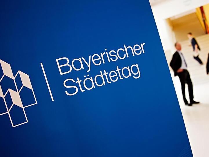 Der Schriftzug "Bayerischer Städtetag" steht auf einem Plakat. Foto: Nicolas Armer/dpa/Symbolbild