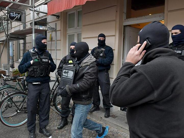 Beschlagnahmt: Ein Polizist verlässt mit einem Computer im Arm die Moschee.