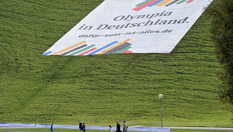 Ein Plakat mit der Aufschrift "Olympia in Deutschland. dafür-sein-ist-alles.de"" liegt auf dem Olympiaberg. Am 26.10.2025 findet der Bürgerentscheid zur Bewerbung der Stadt München um Olympische und Paralympische Spiele statt. Ein Plakat mit der Aufschrift "Olympia in Deutschland. dafür-sein-ist-alles.de"" liegt auf dem Olympiaberg. Am 26.10.2025 findet der Bürgerentscheid zur Bewerbung der Stadt München um Olympische und Paralympische Spiele statt.