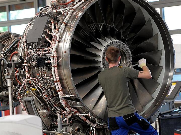 Ein Techniker arbeitet in einer Halle der MTU an einem Flugzeug-Triebwerk. Foto: picture alliance / Peter Steffen/dpa/Symbolbild