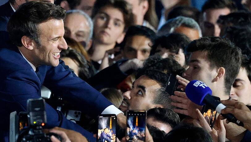 Der wiedergewählte Präsident Macron nimmt auf dem Champ de Mars Glückwünsche entgegen. Der wiedergewählte Präsident Macron nimmt auf dem Champ de Mars Glückwünsche entgegen.