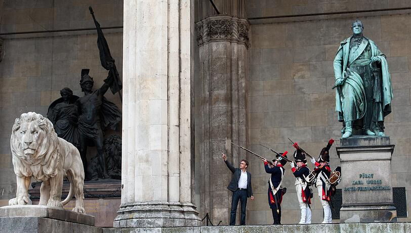 Die vielen Passanten und Touristen schauten verwundert auf dieses Szene: Drei Männer in historischen Soldatenuniformen standen am Freitag neben dem Denkmal des bayerischen Feldmarschalls Fürst Karl Wrede in der Feldherrnhalle am Odeonsplatz.