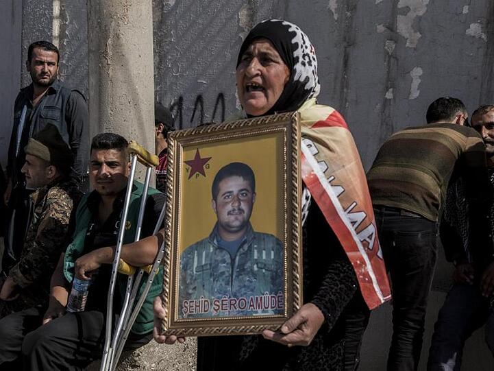 Protest gegen eine mögliche türkische Militäroffensive in Syrien: Eine Frau hält das Porträt eines kurdischen Kämpfers, der im Kampf gegen die Terrormiliz IS getötet wurde.