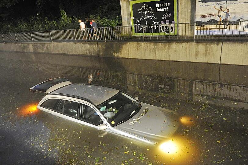 Die Lichter brennen noch: Ein Mercedes war in der überfluteten Bahnunterführung stecken geblieben - und ist völlig absgesoffen.