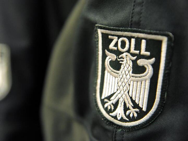 Ein Zollwappen ist an einer Uniformjacke zu sehen. Foto: Maurizio Gambarini/Archiv