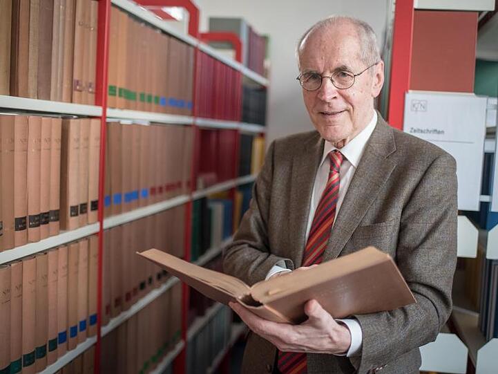 Der Kriminologe Christian Pfeiffer steht vor einer Bücherwand. Foto: Ole Spata/Archivbild