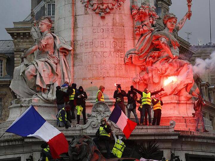 Demonstranten zünden auf dem Place de la Républiquein Paris Pyrotechnik.