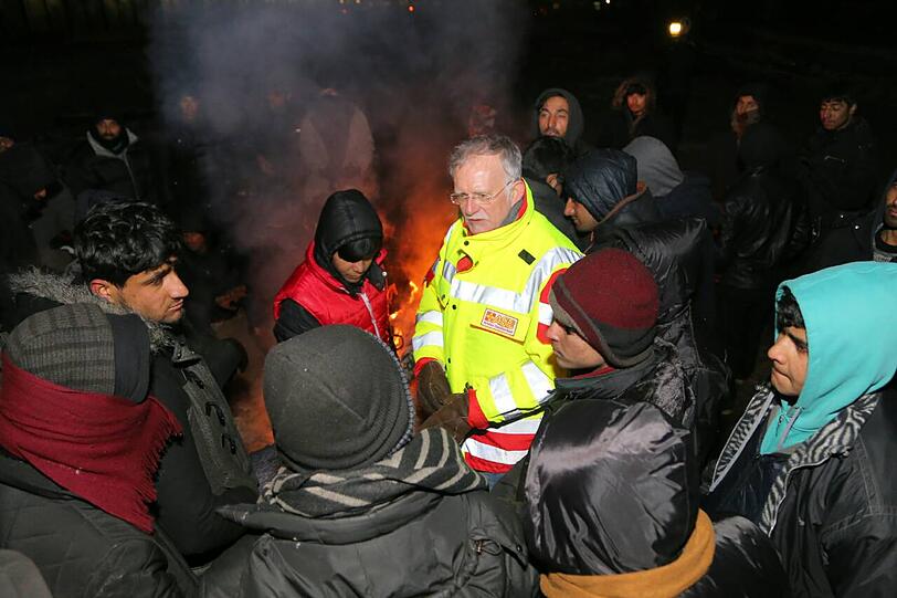An improvisierten Feuern und in der &bdquo;total verfallenen&ldquo; Halle suchen die Flüchtlinge etwas Schutz vor der Kälte.