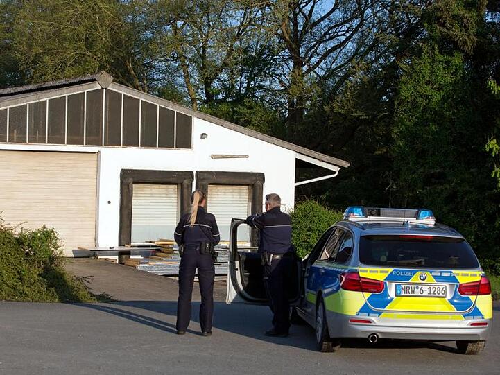 Polizeibeamte stehen vor einer Lagerhalle in der 35.000 Liter verschiedener Chemikalien und 50 Propangasflaschen entdeckt wurden.