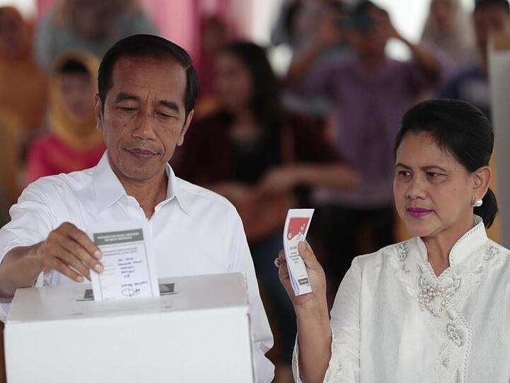 Joko Widodo, Präsident von Indonesien, und seine Frau Iriana geben in einem Wahllokal in Jakarta ihre Stimme ab.