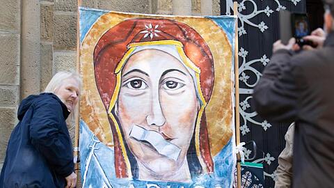 Ein Transparent beim Kirchenstreik "Maria 2.0" zeigt Maria, die Mutter Gottes, mit einem Pflaster auf dem Mund.