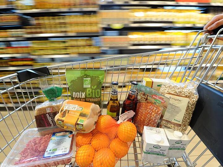 Ein Einkaufswagen mit verschiedenen Bio-Produkten wird durch einen Biomarkt geschoben. Foto: David-Wolfgang Ebener/Archiv