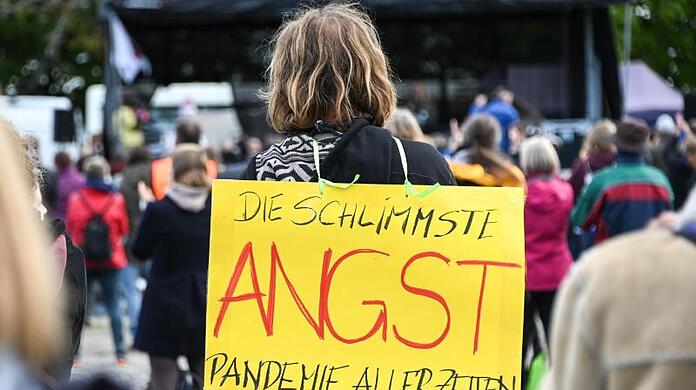 Angst sei die schlimmste Pandemie aller Zeiten, meint dieser Demonstrant bei einem Gottesdienst am Ufer des Bodensees.
