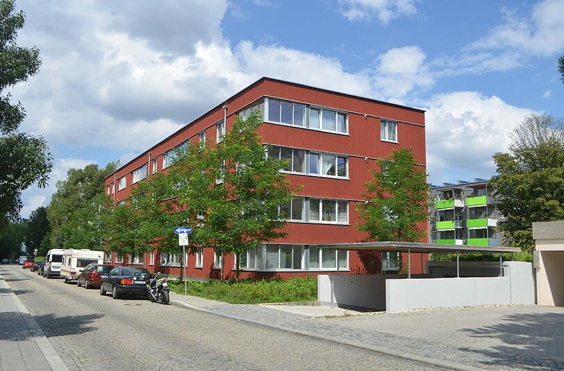 Holzbauten können auch in der Sendlinger Fernpassstraße so rot sein wie in Schweden: Das umgebaute Wohnquartier in Holzbauweise entwarfen Lichtblau Architekten.