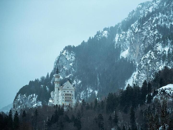 Schloss Neuschwanstein steht in der winterlichen Landschaft. Foto: Lino Mirgeler