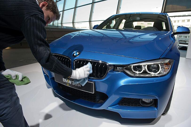 Polieren für die Weltpremiere. BMW-Mitarbeiter vor dem neuen 3er.