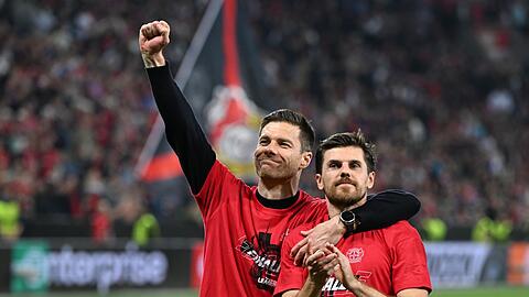Leverkusens Trainer Xabi Alonso und Jonas Hofmann (r) feiern mit den Fans nach dem Spiel gegen Rom.