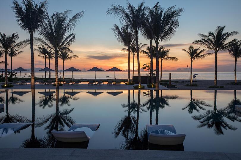 Palmen, Pool und ein zauberhafter Blick aufs Meer: So sieht es am Strand des Alma Resorts in Cam Ranh aus.