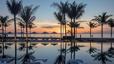 Palmen, Pool und ein zauberhafter Blick aufs Meer: So sieht es am Strand des Alma Resorts in Cam Ranh aus.
