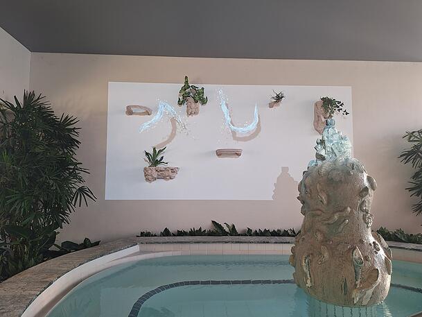 Die Videoprojektion des Künstlers Egil Saebjörnsson wirft Wasserstrahlen auf die Wand, die umherschlängeln. Die Videoprojektion des Künstlers Egil Saebjörnsson wirft Wasserstrahlen auf die Wand, die umherschlängeln.