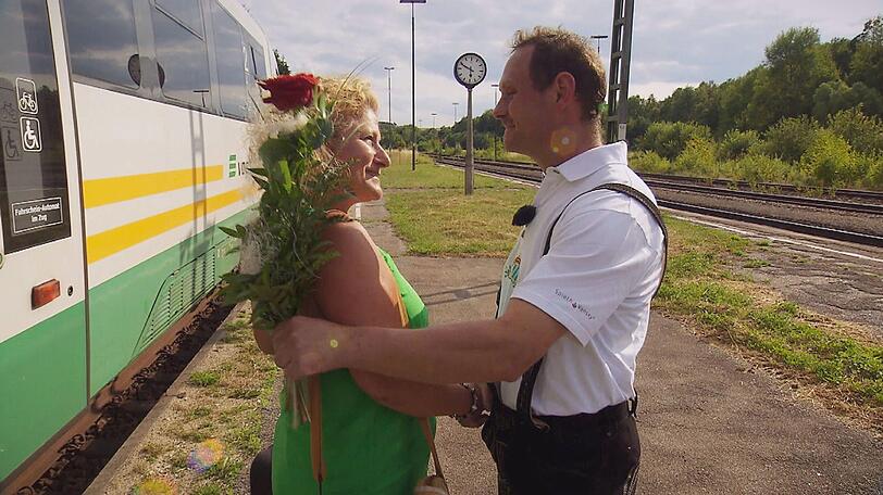 Der sanfte Ackerbauer Markus 'Muck' (40) holt seine Monika mit einer roten Rose vom Bahnhof ab.