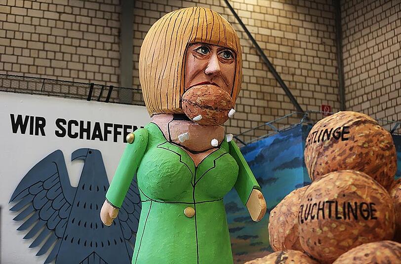 Angela merkel und die Flüchtlinge werden auf diesem Wagen dargestellt.