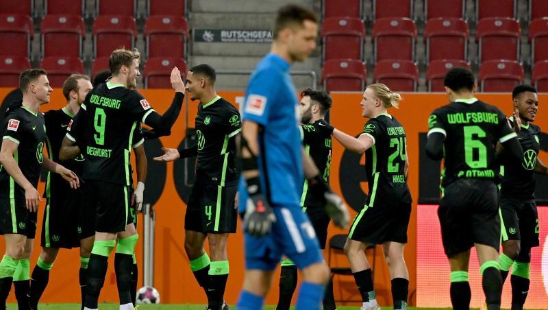 Augsburgs Torwart Rafal Gikiewicz geht nach dem 2:0 an den jubelnden Wolfsburger Spielern vorbei.