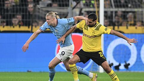 Manchesters Erling Haaland (l) kämpft gegen Dortmunds Emre Can um den Ball.