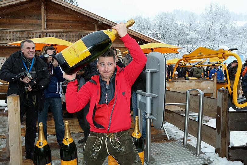 Andreas Georg Gabalier schultert die Magnum-Flasche.
